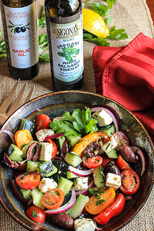 Greek Salad with Baby Heirloom Tomatoes and an Oregano Balsamic Vinaigrette featuring Sigona's Garlic Oil and Oregano White Balsamic Vinegar.  