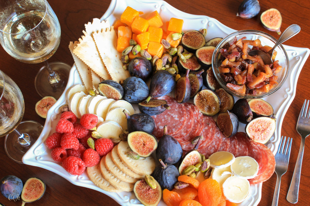 Cheese and fruit charcuterie with fresh figs, dried apricots, wine, nuts and more