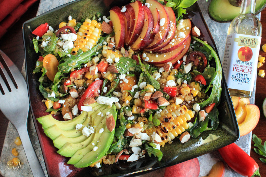 Fresh Peach Grilled Corn and Arugula Quinoa Bowl with a Peach and Baklouti Green Chili Vinaigrette featuring Sigona's Summertime Peach White Balsamic and Sigona's Spicy Baklouti Olive Oil a fantastic loaded salad buddah bowl